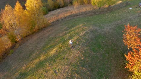 aerial uhd 4k point of view of a man relaxing in the outdoors at autumn. drone flying in circle to capture the subject