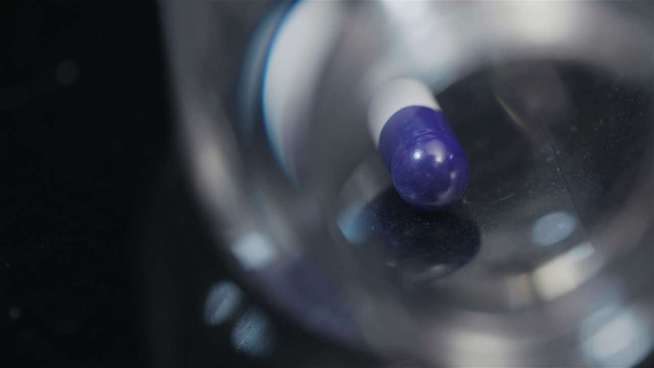 검정색 배경에서 회전하는 작은 병에 든 단일 의료 알약 4