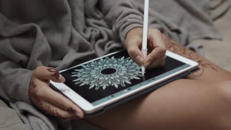 woman drawing mandala on tablet