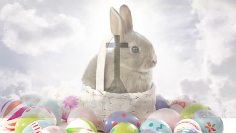 sitting in basket, rabbit surrounded by colorful easter eggs under cloudy sky