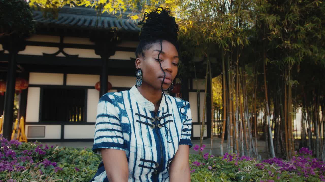 Woman in a garden, Asian style building background