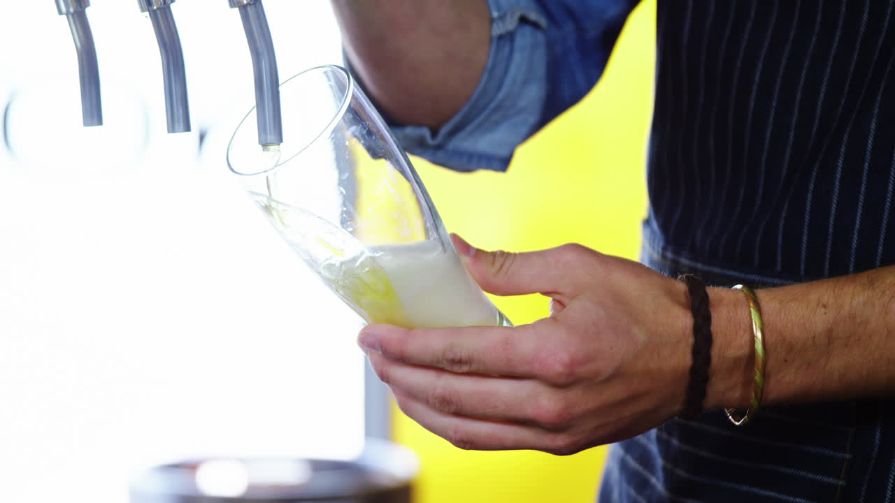 camarero vertiendo cerveza del grifo de la cerveza