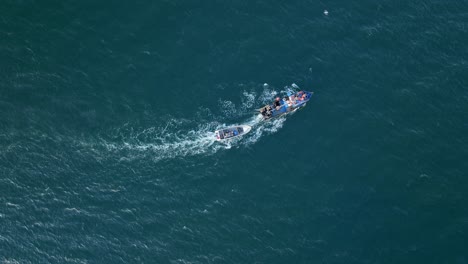 Aerial-Birds-Eye-View-Of-Motorised-Fishing-Boat-Sailing-Across-Waters-Off-Chile-With-Birds-Flying-Overhead