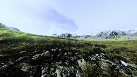 Vast mountain landscape with rocky terrain and gentle grass under a cloudy sky