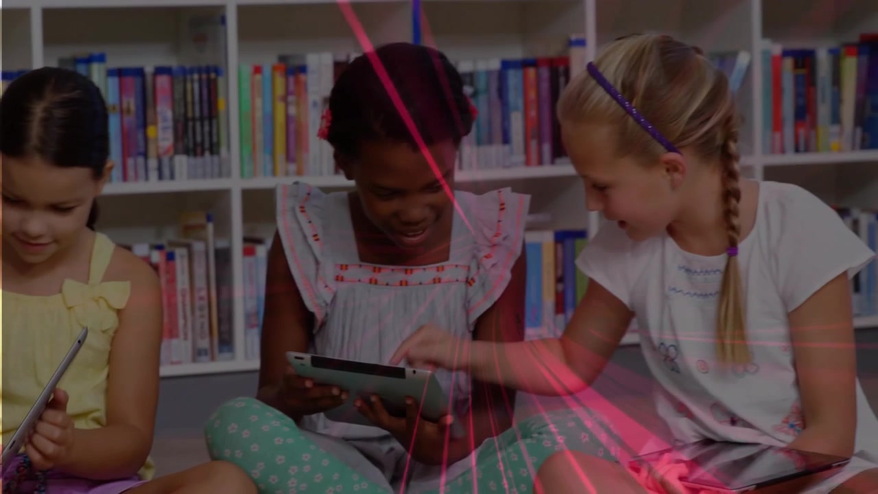 Children in library tapping tablets, sending pink streaks across shelves, joining for learning