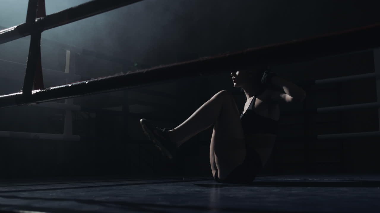 Atleta donna esegue addominali su un ring di pugilato