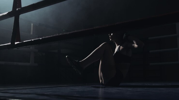 Atleta donna esegue addominali su un ring di pugilato