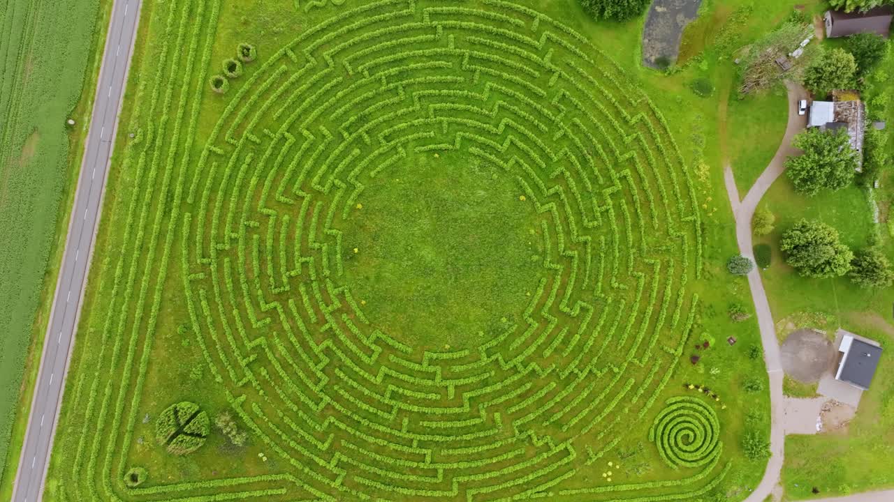 Evergreen circle maze in countryside with drone ascending slowly, Latvia, Europe