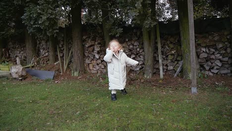 toddler playing and exploring beautiful big garden in winter time, wearing winter clothing