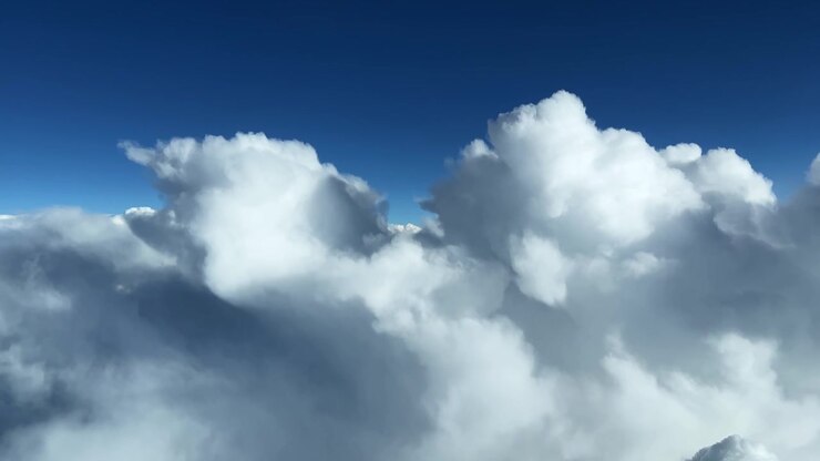 Majestic clouds float effortlessly against a vibrant blue sky, creating a serene and expansive view. Suitable for weather documentaries or nature-themed projects.