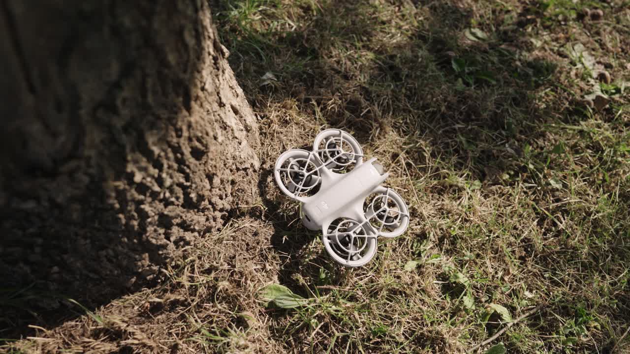 Portable drone in sunny outdoor environment near tree trunk, Czechia