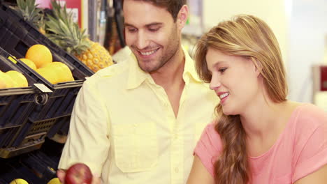 young happy couple buying apples