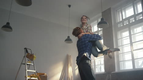 una familia alegre regocijándose en el interior, una pareja feliz divirtiéndose en la nueva casa.