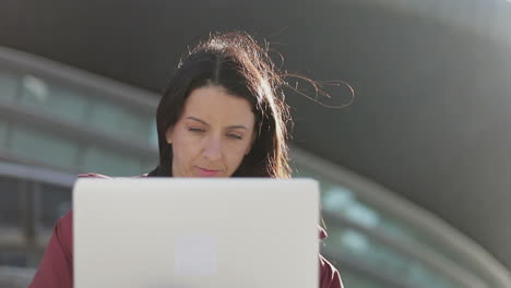 mujer madura y hermosa que trabaja con un portátil al aire libre