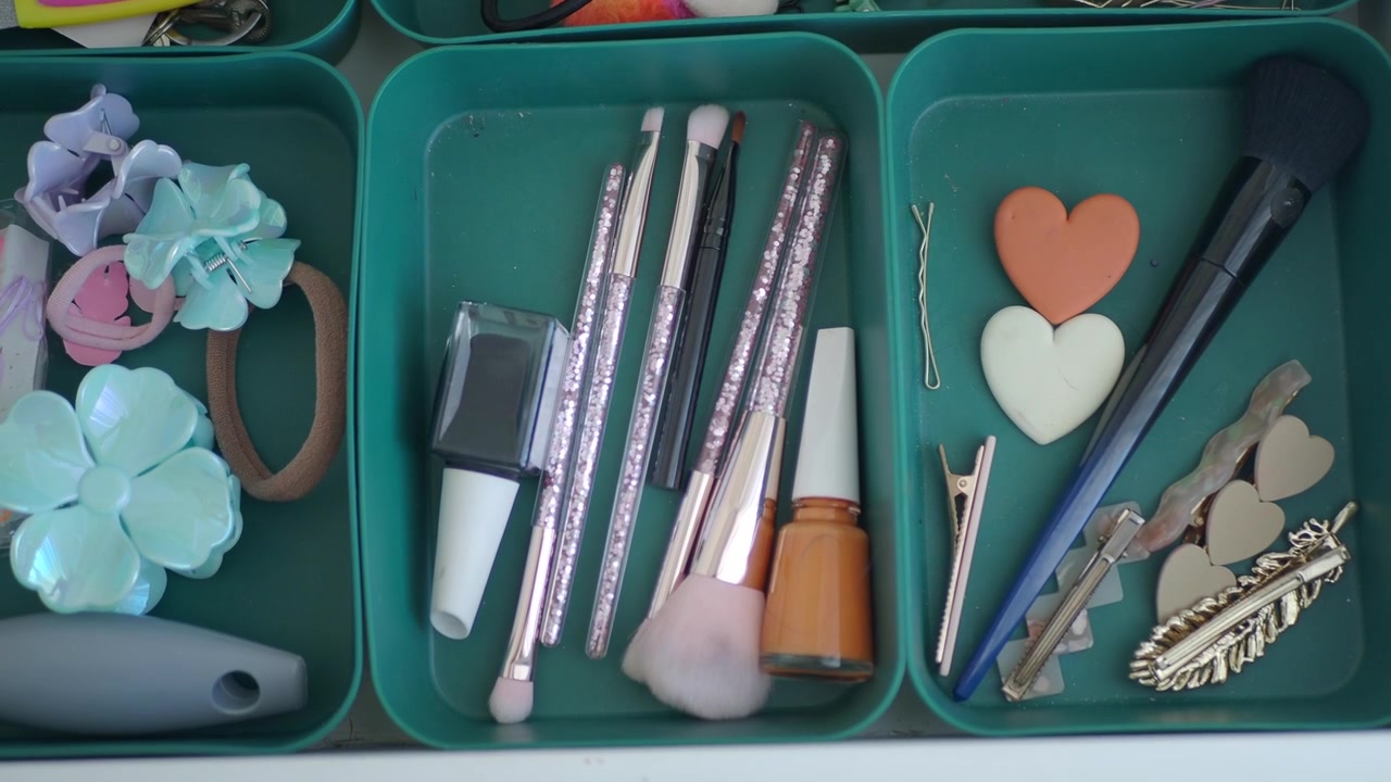 Trucchi e accessori per capelli organizzati in vassoi per cassetti