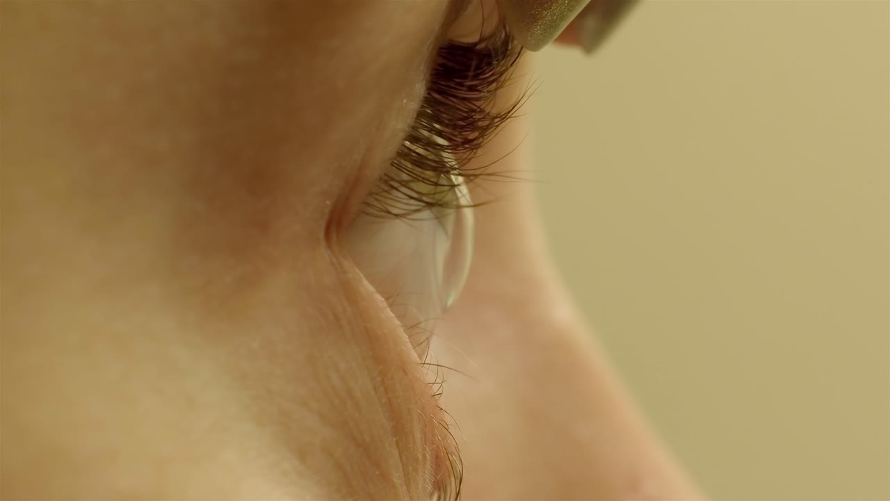 Failed attempt: woman struggles placing contact lens in her eye