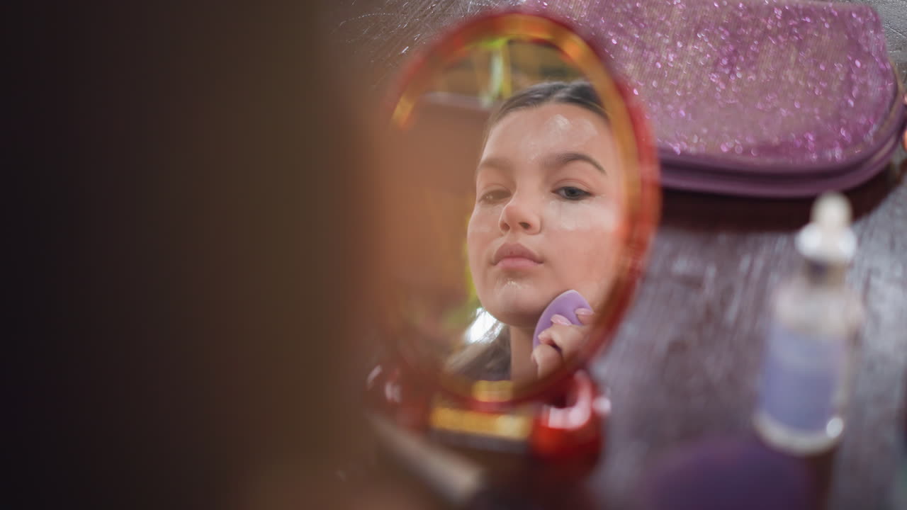 Close-up mirror reflection of young woman applying powder to her face with purple makeup sponge, showcasing beauty routine for flawless makeup application, smoothing skin