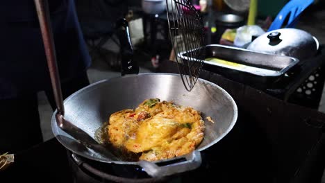 street vendor frying and serving an egg