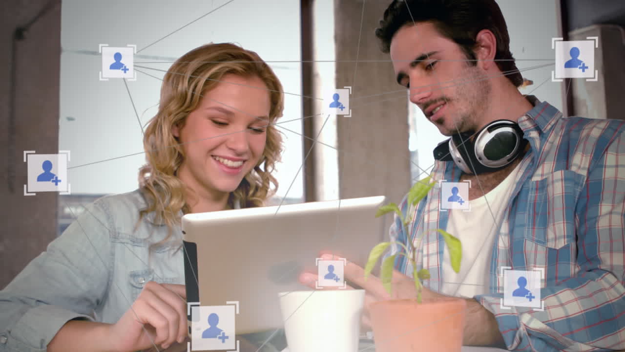 animación de una red de iconos sobre un hombre y una mujer usando una tableta en la oficina