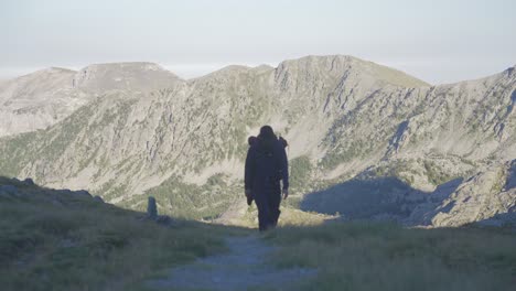 un hombre caminando solo en las montañas, caminando hacia la cámara