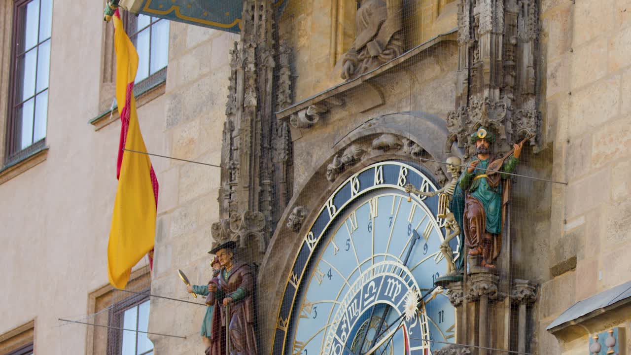 Medieval astronomical clock rotates, revealing zodiac signs and statues in daylight, Prague city landmark