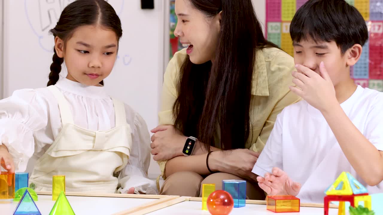 明るく楽しげな教室で、2人の子供と先生がカラフルな積み木で遊んでいます。