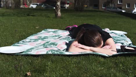 woman laying on a blanket in the sun after a hard workout, totally exhausted