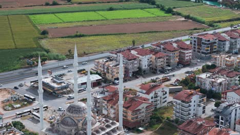 Aerial-view-flyover-Manavgat-mosque,-Turkey,-Approaching-farmland-fields-in-the-Antalya-region