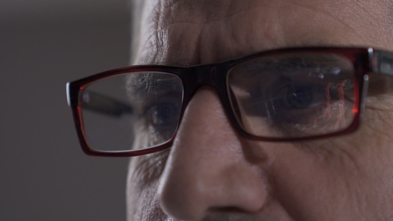 un comerciante maduro analizando un mercado de valores y un gráfico de criptomonedas.