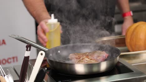 chef freyendo un filete en una sartén