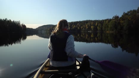 woman paddling canoe boat on beautiful autumn lake, rear view-1