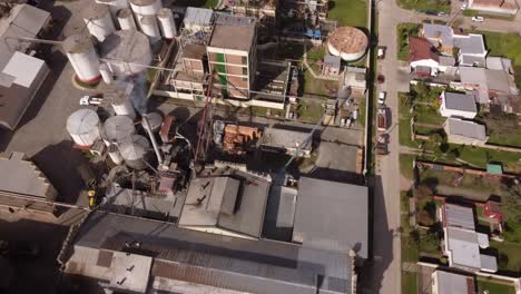 Aerial-top-down-orbiting-over-industrial-chimney-of-food-factory-in-Buenos-Aires-province,-Argentine