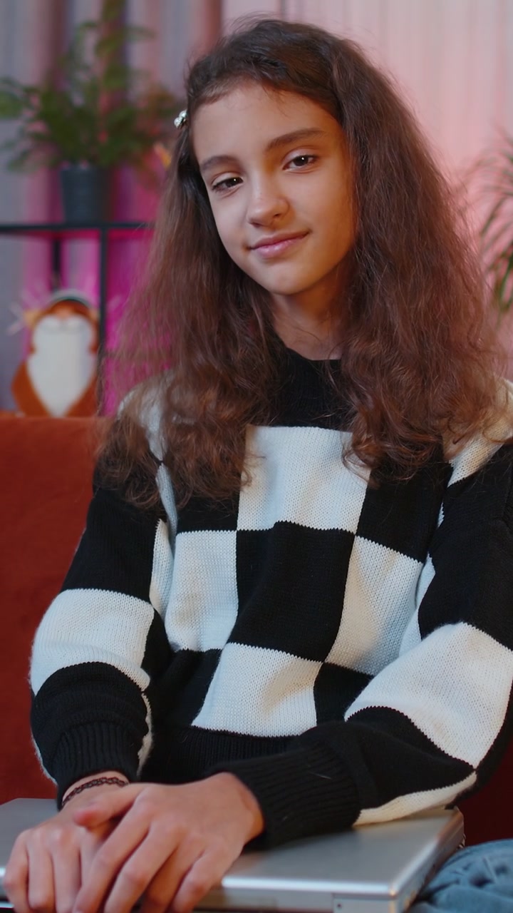 Giovane ragazza freelancer sdraiata sul divano, chiude il PC portatile dopo aver terminato il lavoro nel salotto di casa.