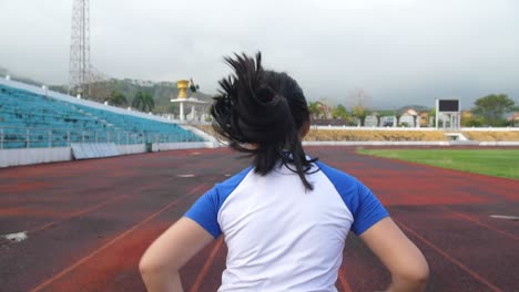 back view of little girl running at stadium