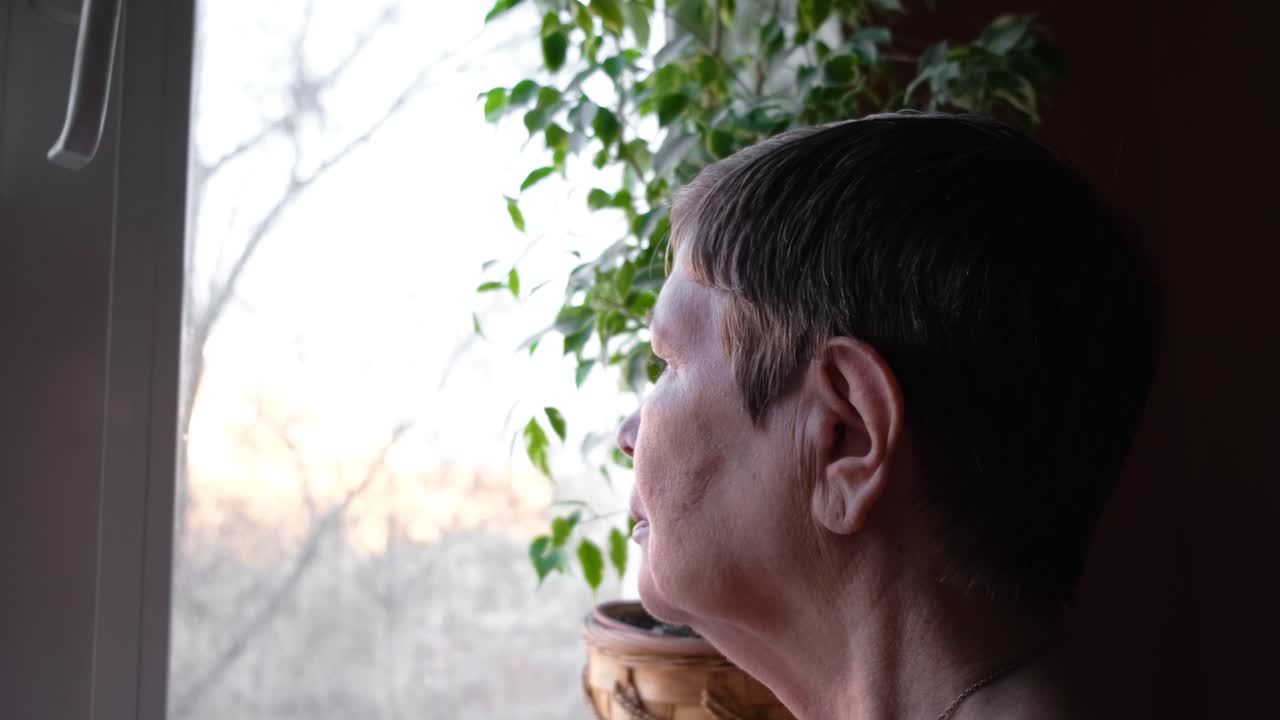 창밖을 바라보는 고령 여성