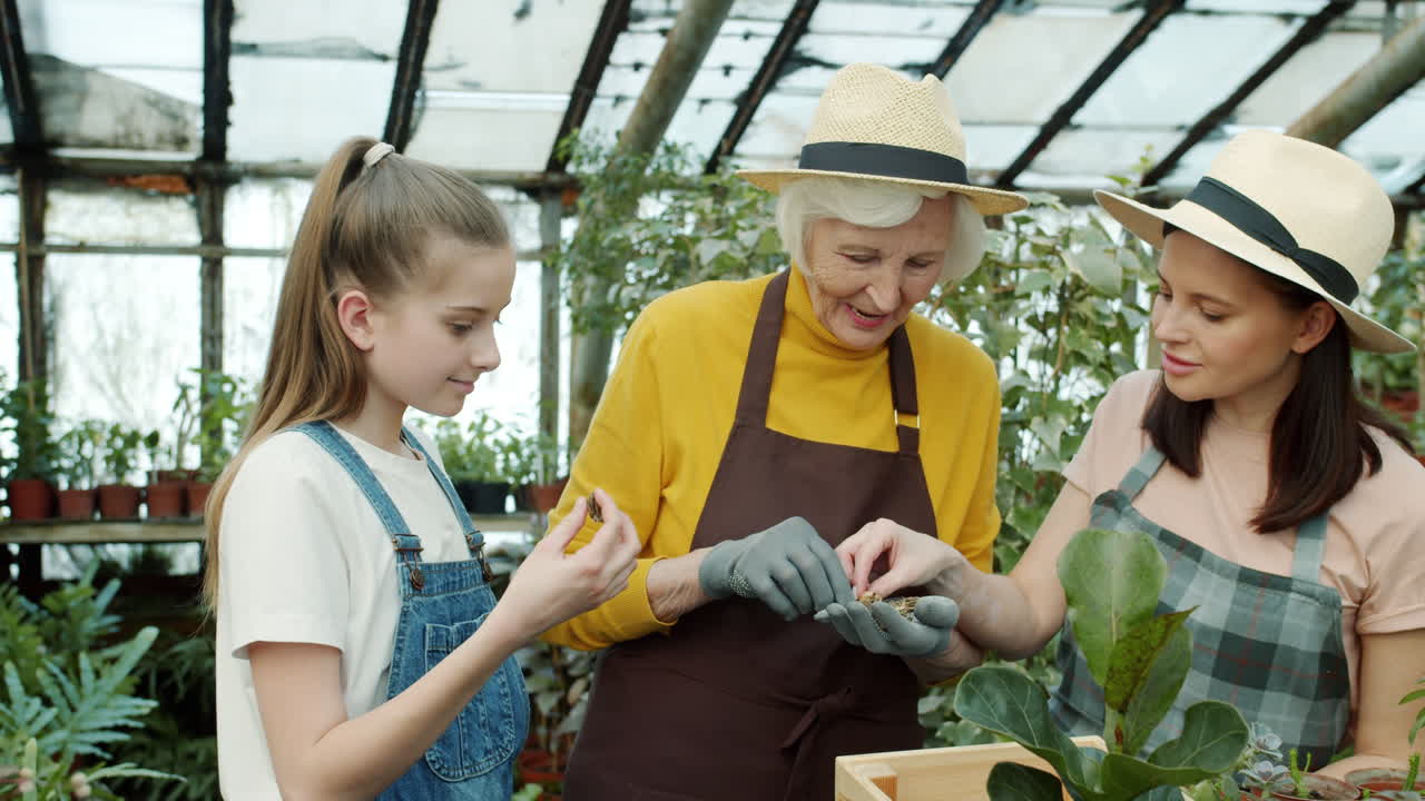 Grandmother, daughter, and granddaughter gardening in greenhouse