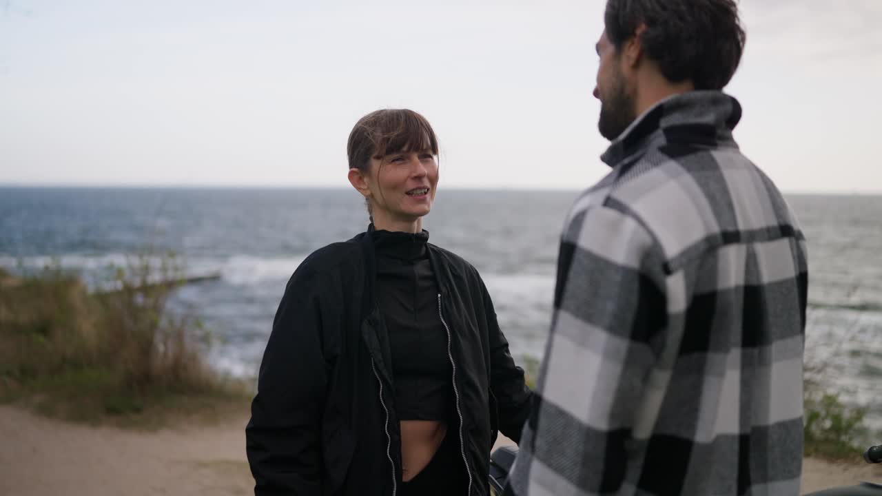una pareja hablando en la playa.