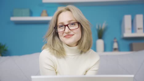 Una-Joven-Feliz-Con-Gafas-Mirando-A-La-Cámara-Y-Sonriendo-En-Casa