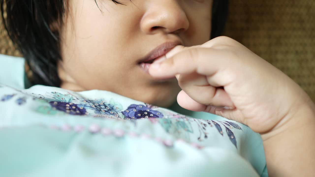 Ragazza del bambino che si morde le unghie a casa
