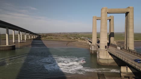 Zwei-Personen-Auf-Jetskis-Genießen-Einen-Sommertag-Voller-Action-Sportarten-In-Der-Nähe-Der-Sheepney-Kreuzung-Und-Der-Kingsferry-Brücke-In-Kent,-England