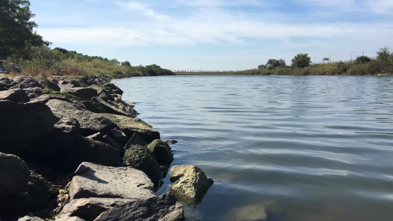 Calm River with Rocky Bank Under a Blue Sky