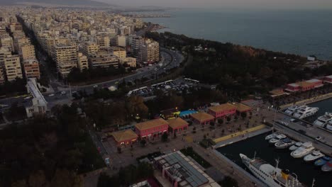 Vista-Aérea-Del-Puerto-Deportivo-De-Flisvos-Y-El-Tráfico-Costero-En-Atenas,-Grecia-En-El-Crepúsculo,-Disparo-De-Drones