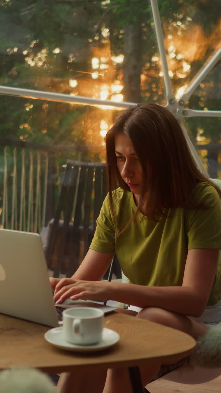 mujer ocupada freelance utiliza la computadora portátil para trabajar en línea en casa sentada en el sillón con una taza de café por la mañana. mujer enfocada corrige el cabello que cae en la cara
