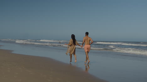 cute couple running at the beach