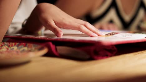 a person flips through a menu at a mexican restaurant in bangkok. warm lighting and close-up focus create an inviting atmosphere