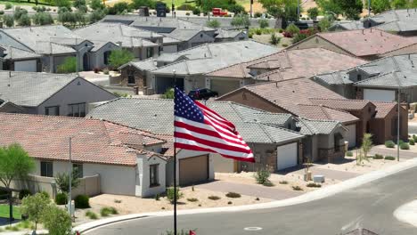 Bandera-Americana-Ondeando-Frente-A-Casas-De-Estilo-Suroeste-En-Estados-Unidos