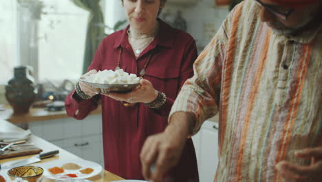 two culinary bloggers cooking indian food and explaining recipe on camera