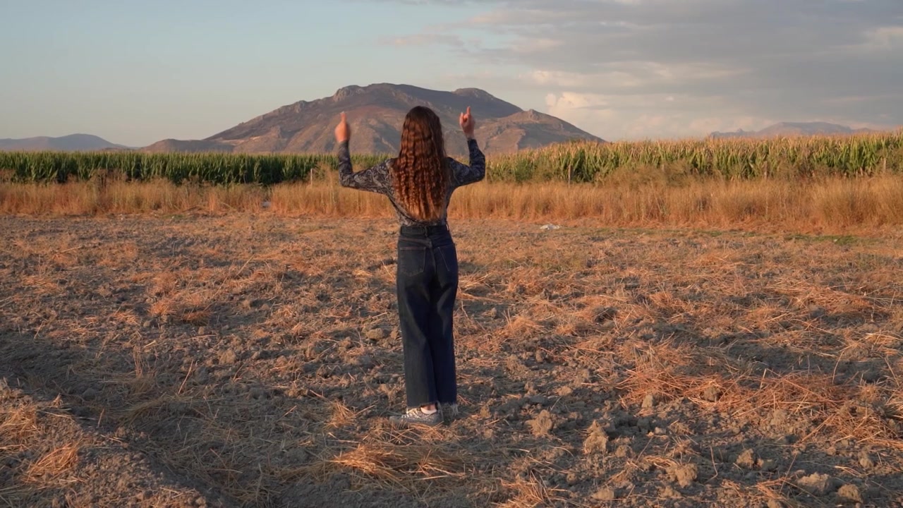 Una donna che abbraccia la bellezza della natura in un paesaggio suggestivo e affascinante durante un tramonto mozzafiato.