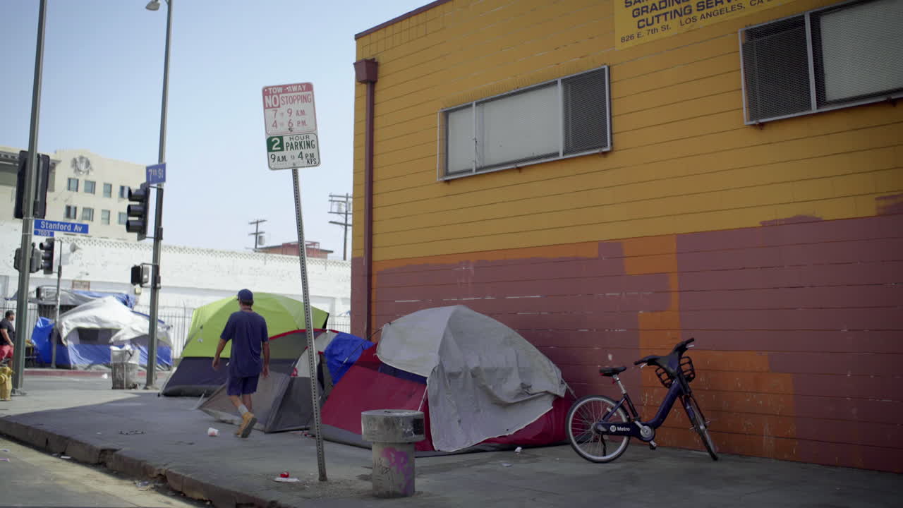 Scenes of a homeless encampment on urban streets during the day