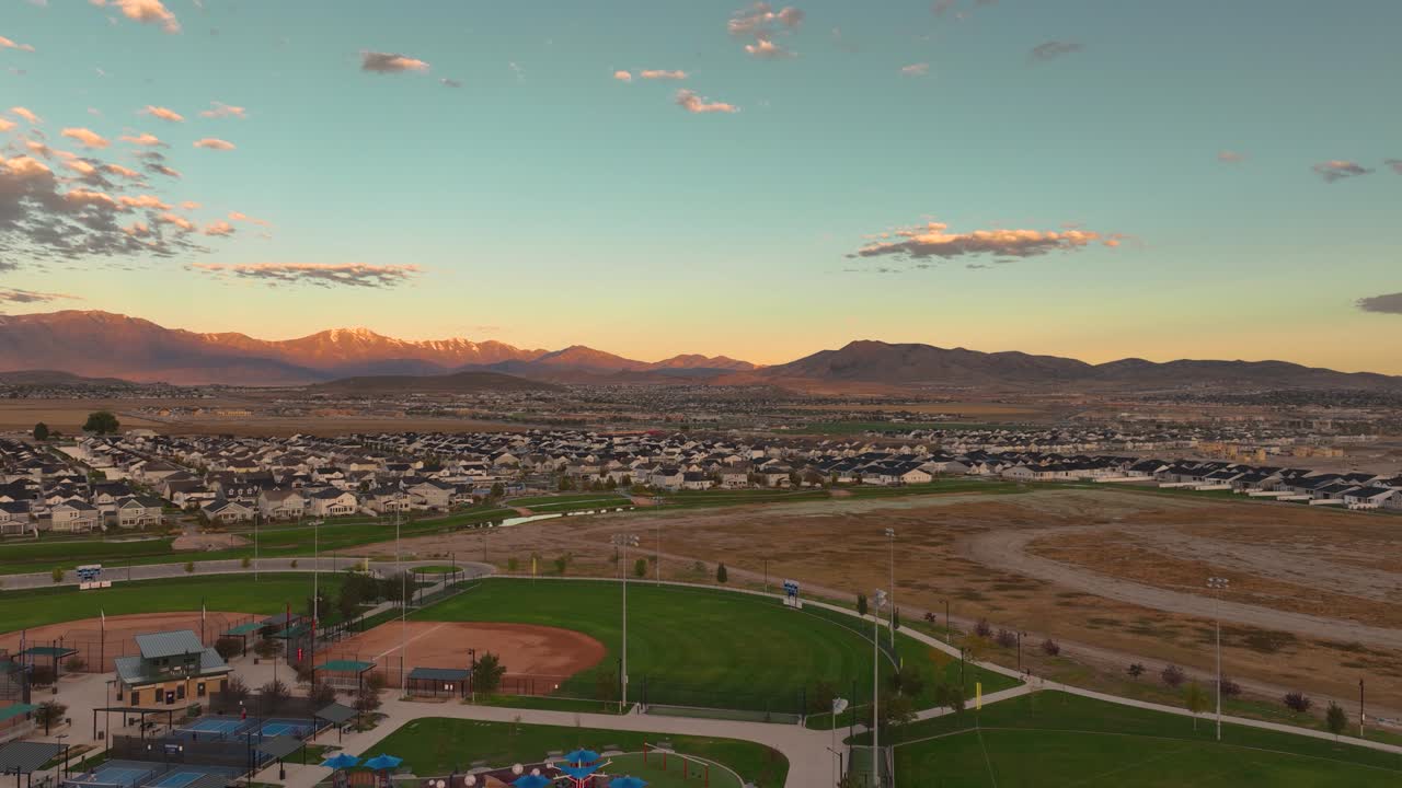 Aerial Flyover Of Patriot Park Sports Fields And Playground In A Neighborhood Of Saratoga Springs In Utah, USA at sunrise